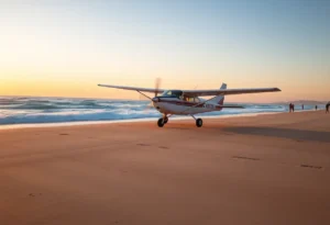 A small plane landing on Huntington Beach at sunset